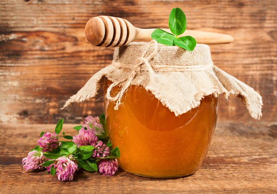 clover honey with pink flowers showing natural honey benefits