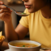 woman in yellow tee shirt eating soup
